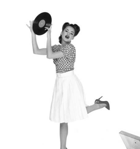emotional woman in pin up style clothing with vinyl record in hands standing near phonograph