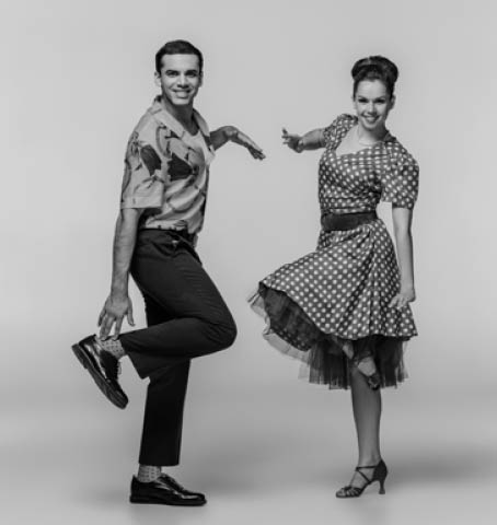 stylish dancers looking at camera while dancing boogie-woogie on grey background