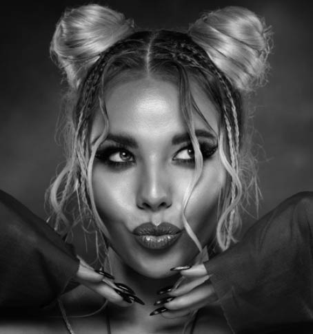 Beauty Girl with pout Full Lips Kiss. Beauty Model Face with Perfect Make up and Black Nails Manicure. Stylish Blond Woman with Two Space Hair Buns Hairstyle over Dark background