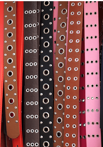 A closeup shot of colorful leather belts with rivets for sale