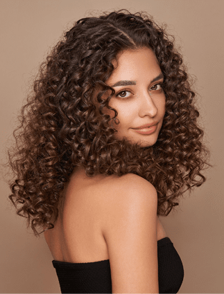Fashion studio portrait of beautiful smiling woman with afro curls hairstyle. Fashion and beauty