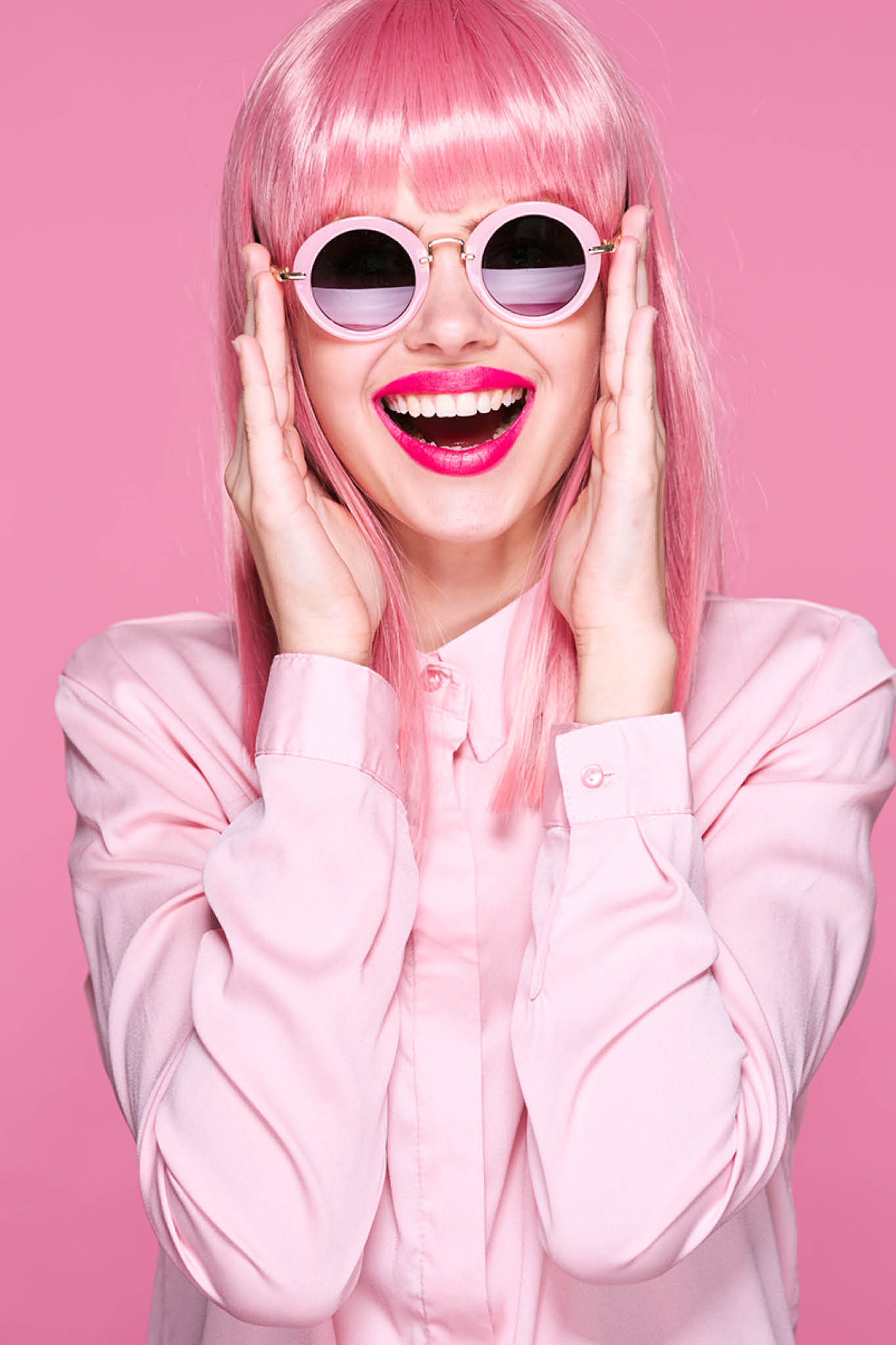 Cheerful woman studio party model pink hair smile