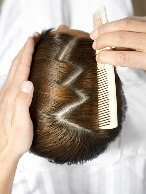 high angle view of hairdresser using comb